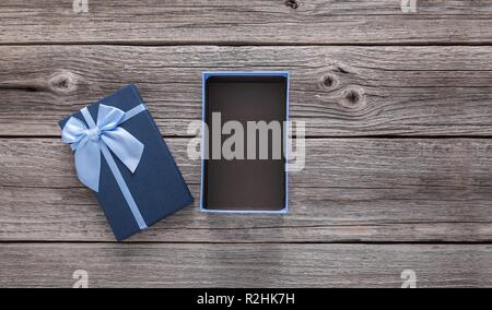 Open gift box on the background of wooden boards. Stock Photo