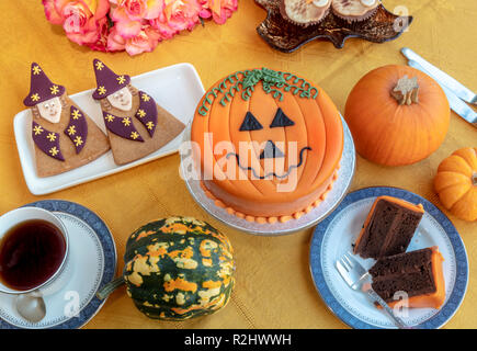 Novelty cake decorated with marzipan and icing in Halloween pumpkin theme. Stock Photo