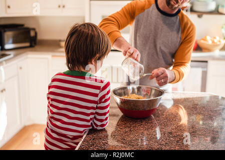 Boy helping his father bake in the kitchen Stock Photo