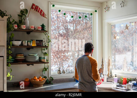 Man standing in the kitchen doing the dishes Stock Photo
