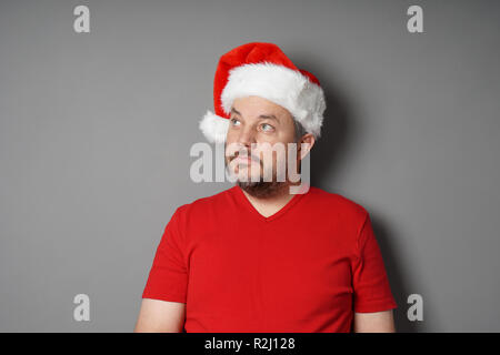 man wearing santa hat looking up to copy space Stock Photo