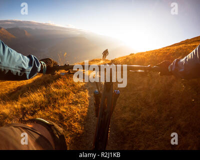 Personal perspective shot of a man mountain biking with a friend in the Alps, Gastein, Salzburg, Austria