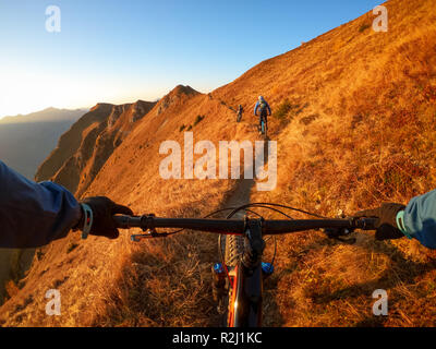 Personal perspective shot of a man mountain biking with friends in the Alps, Gastein, Salzburg, Austria