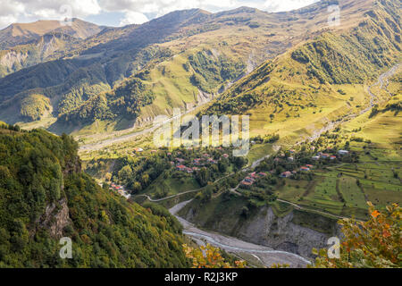 Scenic view from Georgian Military Road to village on mountainside and valley of Aragvi River