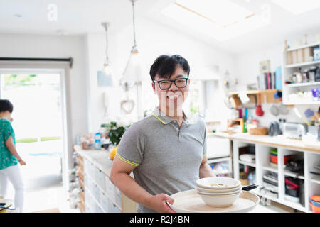 Portrait smiling man doing dishes in kitchen Stock Photo