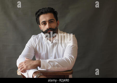 Portrait confident young man with handlebar mustache Stock Photo