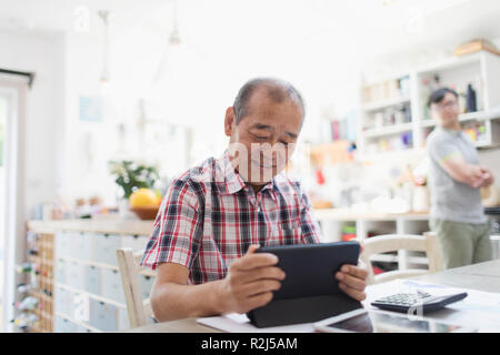 Senior man using digital tablet in kitchen Stock Photo