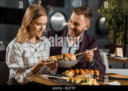 Happy attractive young adult couple having dinner in restaurant Stock Photo