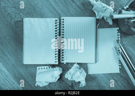 Crumpled empty pages and notebook lying on wooden surface Stock Photo