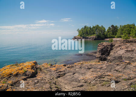 Rocky shoreline covered with lichen along the shore of Lake Superior Stock Photo