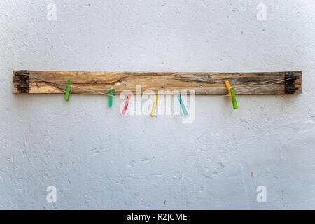 Plastic colorful laundry clips on rope on the background Stock Photo