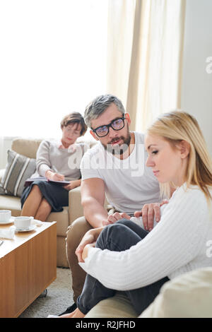 Young wife feeling sorrow at therapy session Stock Photo