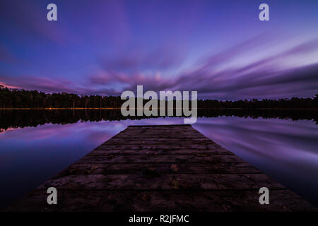 View of a peaceful lake and a Beautiful sky. Long exposure with Clouds Looking like fluids. Blue hour in the morning. Stock Photo