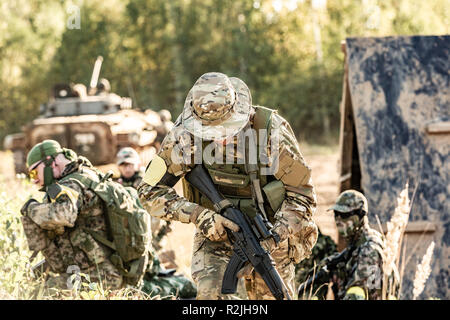 Sniper team armed with large caliber, sniper rifle, shooting enemy targets on range from shelter, sitting in ambush Stock Photo