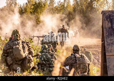 Sniper team armed with large caliber, sniper rifle, shooting enemy targets on range from shelter, sitting in ambush Stock Photo