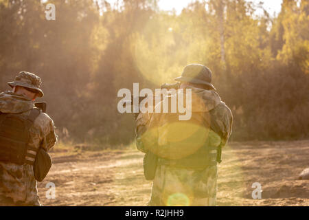 Sniper team armed with large caliber, sniper rifle, shooting enemy targets on range from shelter, sitting in ambush Stock Photo