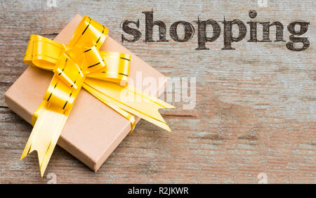 Gift box on wooden background, with text shopping. Top view. Stock Photo