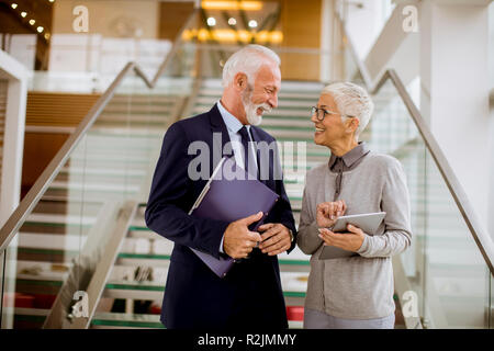 Portrait of a senior businessman  holding documents and businesswoman holding tablet computer were discussing jobs in modern office Stock Photo