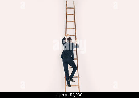 A man in a black suit climbs the stairs. Career and growth in business concept. Stock Photo