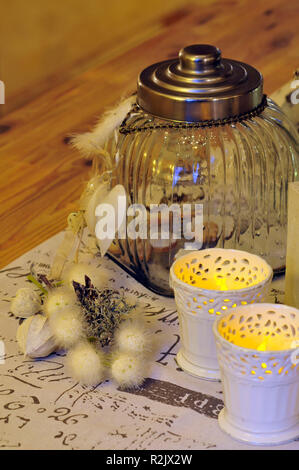 Christmas table decoration in white with candles and glass storage tin with biscuits Stock Photo