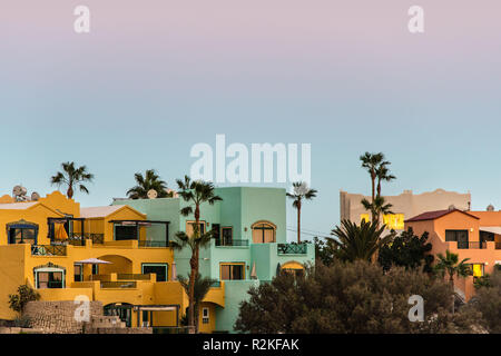 Colorful housing complex with palm trees in front of a evening sky at the coast of Tenerife. Stock Photo