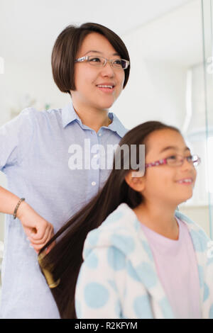 Mother brushing daughters hair Stock Photo