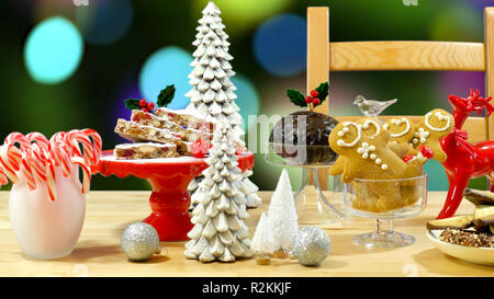 Festive table with traditional English and European style Christmas food including panforte cake, plum pudding, gingerbread cookies, and chocolate cov Stock Photo