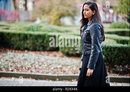 Pretty indian girl in black saree dress and leather jacket posed