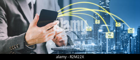 Double exposure banner of entrepreneur businessman using smartphone sending email on cityscape background. Business communication, internet technology Stock Photo