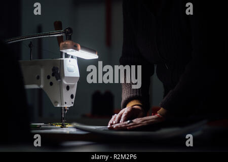 Working Woman hands in textile factory sewing on industrial sewing ...