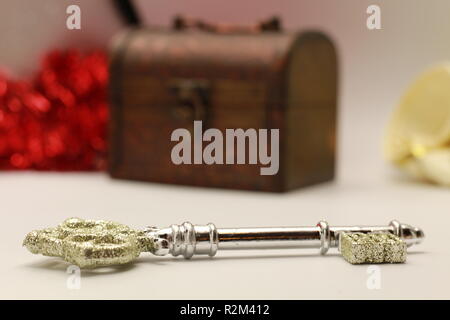 Glittering Key Close Up with a wooden box and Christmas Tree ornaments in the background Stock Photo