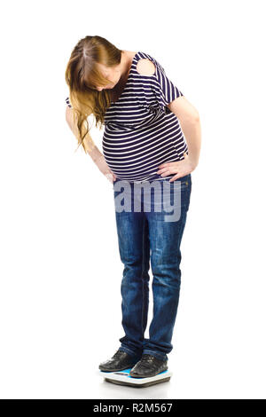 pregnant woman on a scales isolated on a white background Stock Photo