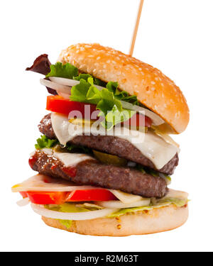 double tasty hamburger with beef cutlet, fresh vegetables and cheese. Isolated over white background Stock Photo