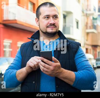 attractive man in city with phone in his hands outdoors Stock Photo