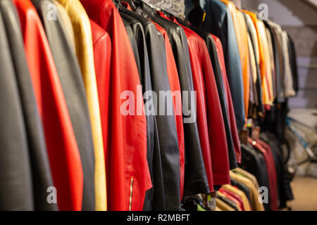Collection of leather jackets on clothing hangers in shop Stock Photo