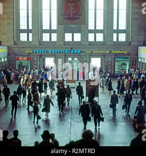 Travel on the Leipzig main station, travellers in the station hall, right and left ticket office, at the entrance DDR emblem and newspaper advertisement Stock Photo
