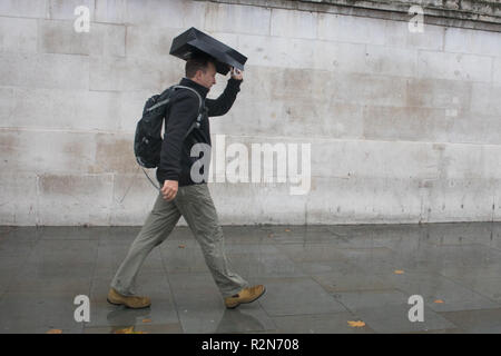 London UK. 20th November 2018. Pedestrians shelter under umbrellas from the cold freezing rain in Trafalgar Square London Credit: amer ghazzal/Alamy Live News Stock Photo