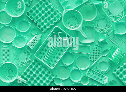 Close up flat lay of different teal blue color painted kitchen utensils and tools, grater, spoon, egg carton, plastic disposable plates, elevated top  Stock Photo