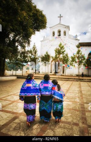 Traditionally dressed ladies walk across the plaza in Zinacantan, Chiapas, Mexico. Stock Photo