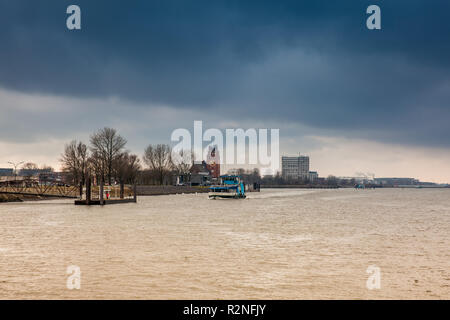Ferry navigating on the Elbe river in a cold cloudy winter day in Hamburg Stock Photo