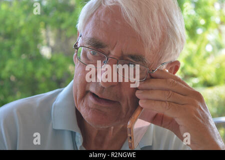 Senior man on a mobile phone, talking and looking concerned Stock Photo