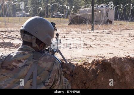 South Carolina Army National Guard Soldiers from 4th Battlion, 118th Regiment and 174th Engineer Company conduct combined arms breaching exercises at McCrady Training Center, Eastover, S.C., Nov. 3, 2018.  The 4th Battalion infantry companies practiced attacking an objective using support from the 174th engineer mobility assault platoons for obstacle reduction, destruction and short-gap crossings.  The combined forces breached wired obstacles using simulated M58 Mine Clearing Line Charge (MICLIC) rockets, cleared minefields with an M9 Armored Combat Earthmover (ACE), and placed a bridge over a Stock Photo