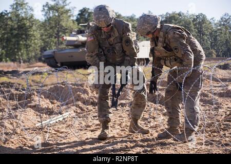 South Carolina Army National Guard Soldiers from 4th Battlion, 118th Regiment and 174th Engineer Company conduct combined arms breaching exercises at McCrady Training Center, Eastover, S.C., Nov. 3, 2018.  The 4th Battalion infantry companies practiced attacking an objective using support from the 174th engineer mobility assault platoons for obstacle reduction, destruction and short-gap crossings.  The combined forces breached wired obstacles using simulated M58 Mine Clearing Line Charge (MICLIC) rockets, cleared minefields with an M9 Armored Combat Earthmover (ACE), and placed a bridge over a Stock Photo