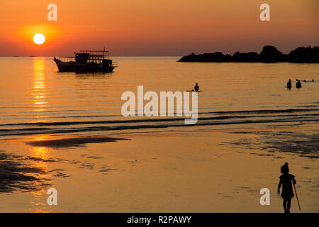 Sunset over the sea, silhouette of a girl in the foreground, Ko Chang, Thailand Stock Photo