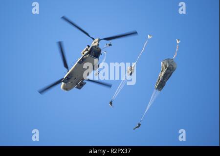 Army paratroopers assigned to the 4th Infantry Brigade Combat Team (Airborne), 25th Infantry Division, U.S. Army Alaska, jump from a CH-47 Chinook helicopter during airborne training at Joint Base Elmendorf-Richardson, Alaska, Nov. 1, 2018. The Soldiers of 4/25 belong to the only American airborne brigade in the Pacific and are trained to execute airborne maneuvers in extreme cold weather and high altitude environments in support of combat, partnership and disaster relief operations. Army aviators from B Company, 1st Battalion, 52nd Aviation Regiment out of Fort Wainwright, operated CH-47 Chin Stock Photo