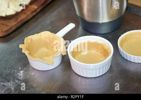 Preparation of mini-tarts, fitting dough into baking molds Stock Photo