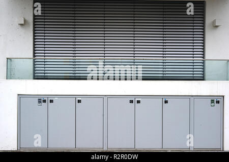 Apartment house, new modern balcony, white facade and lockable waste storage sheds Stock Photo