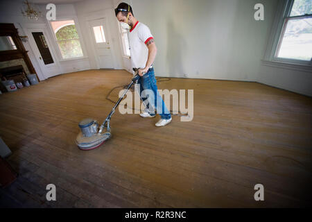 Male builder buffing floorboards inside a room Stock Photo - Alamy