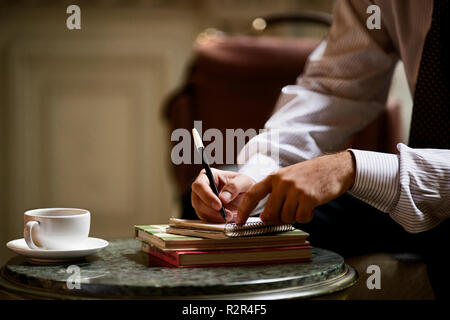 Cropped view of a man writing on a notepad. Stock Photo