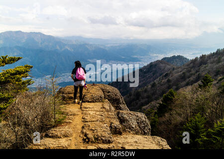 A woman admiring the spectacular view after a long hike taken from the mountains surrounding Mt. Fuji Stock Photo